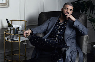 Image of Drake sitting in a chair wearing an Armani suit