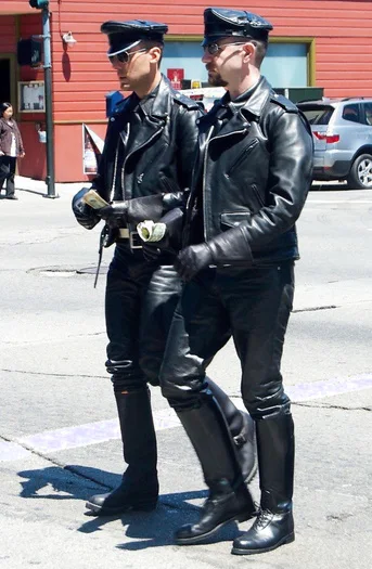 Two leather men in full gear walking down the street together
