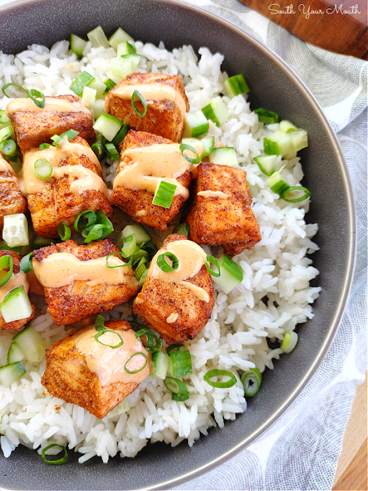 Baked Bang-Bang Salmon Bites! Salmon fillet chunks seasoned with simple Asian-inspired spices, baked hot and fast until crispy served with an easy Bang Bang Sauce recipe for dipping or in a rice bowl with cucumbers and scallions.