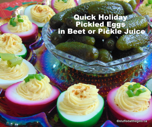 A platter of deviled eggs made from the red and green pickled eggs. White eggs are regular deviled eggs. There is a small dish of gherkin pickles in the middle of the platter.