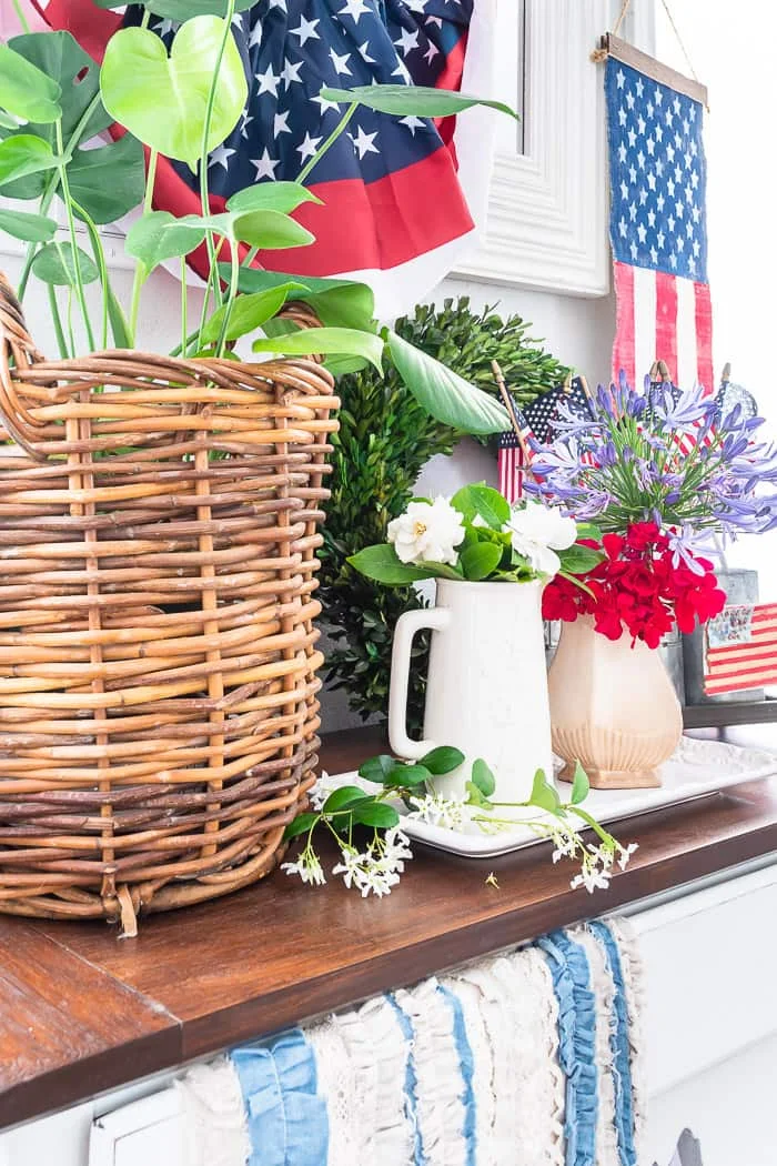 wood table with basket of greenery, flags, flowers