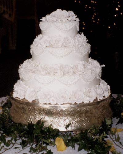 Elaborately decorated gorgeous white wedding cake with plenty of sugar roses