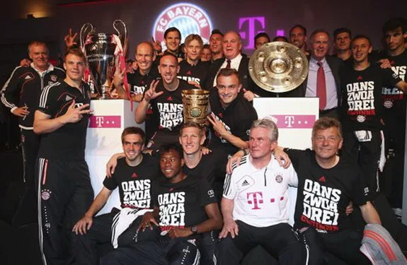 Bayern Munich team pose with their Champions League, DFB Pokal, and Bundesliga trophies