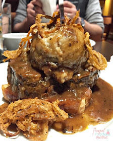 The Mile High Meatloaf from Appalachian Brewing Company is a thick slice of tender Angus beef meatloaf that is served over Texas Toast and then topped with a beer gravy, garlic mashed potatoes, and crispy fried onion straws