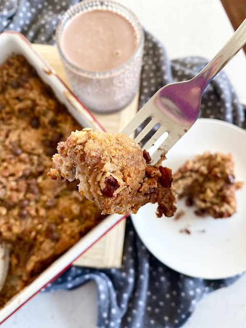 A close up of chocolate croissant breakfast bake on a fork with the dish in the background.