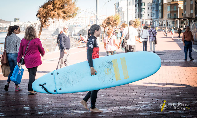 Chica con tabla de surf en la playa de Las Canteras