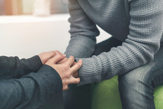 closeup of two people holding hands and showing support