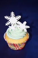 Lemon cupcakes topped with a pale blue buttercream swirl and fondant snowflakes