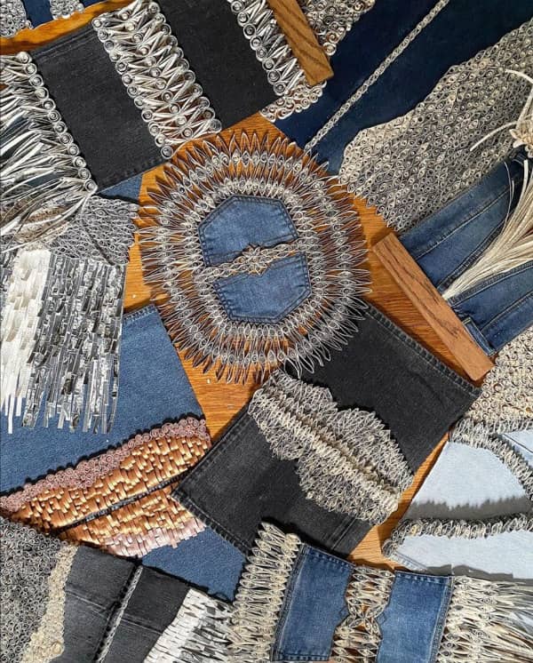 grouping of denim and paper quilling wall hangings displayed on wood floor