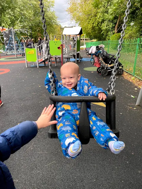 8 month old baby boy being pushed in a swing