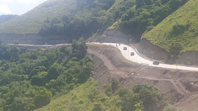 Foto Rute jalan yang berkelok dikelilingi pegunungan Golo Mori