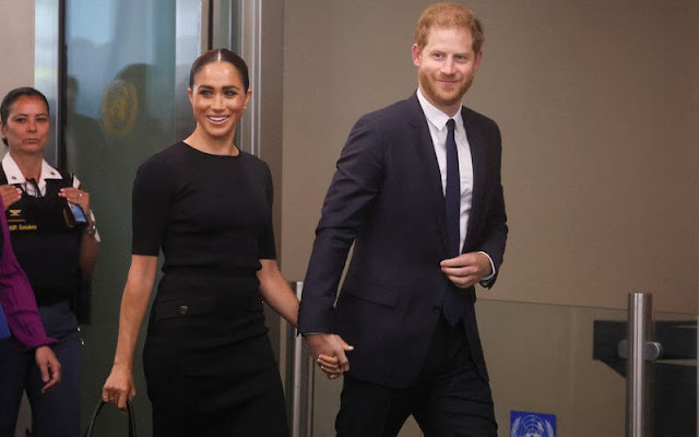 Meghan Markle wore a black knit gold button pencil skirt by Givenchy. Mulberry leather bag. Manolo Blahnik suede pumps