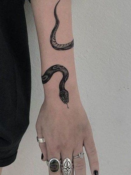 black-ink-snake-on-woman's-wrist-tattoo