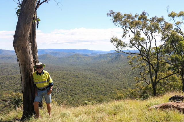 Al leaning on a tree with view of distant mountains