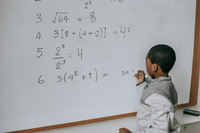 black-schoolboy-solving-math-examples-on-whiteboard-in-classroom