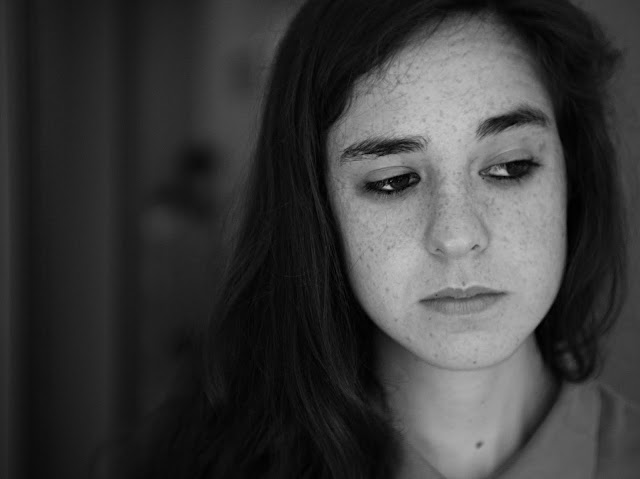 fotografía de una chica con mirada triste y esquiva.