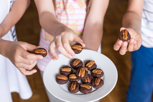 Raw chocolate pekan bites in hands of children