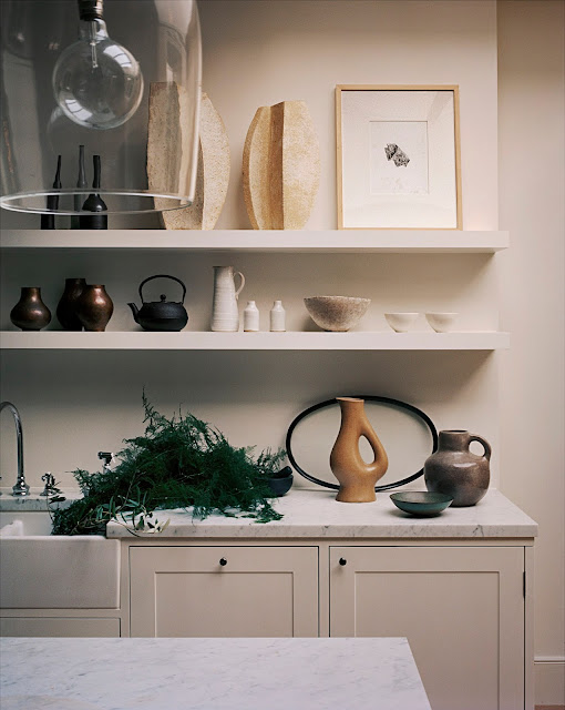 open shelves in kitchen to display collection of art and antiques