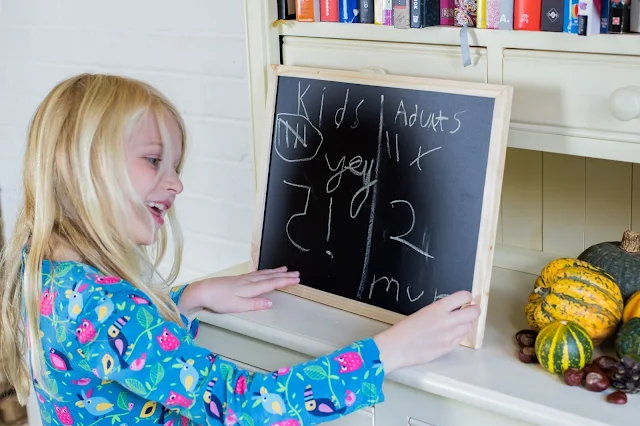 A child writing happily on a blackboard that the children won