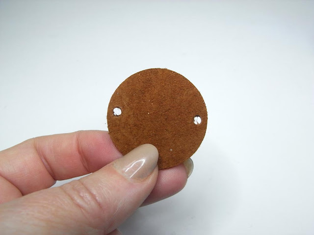 Brown suede circle with holes punched on opposite sides
