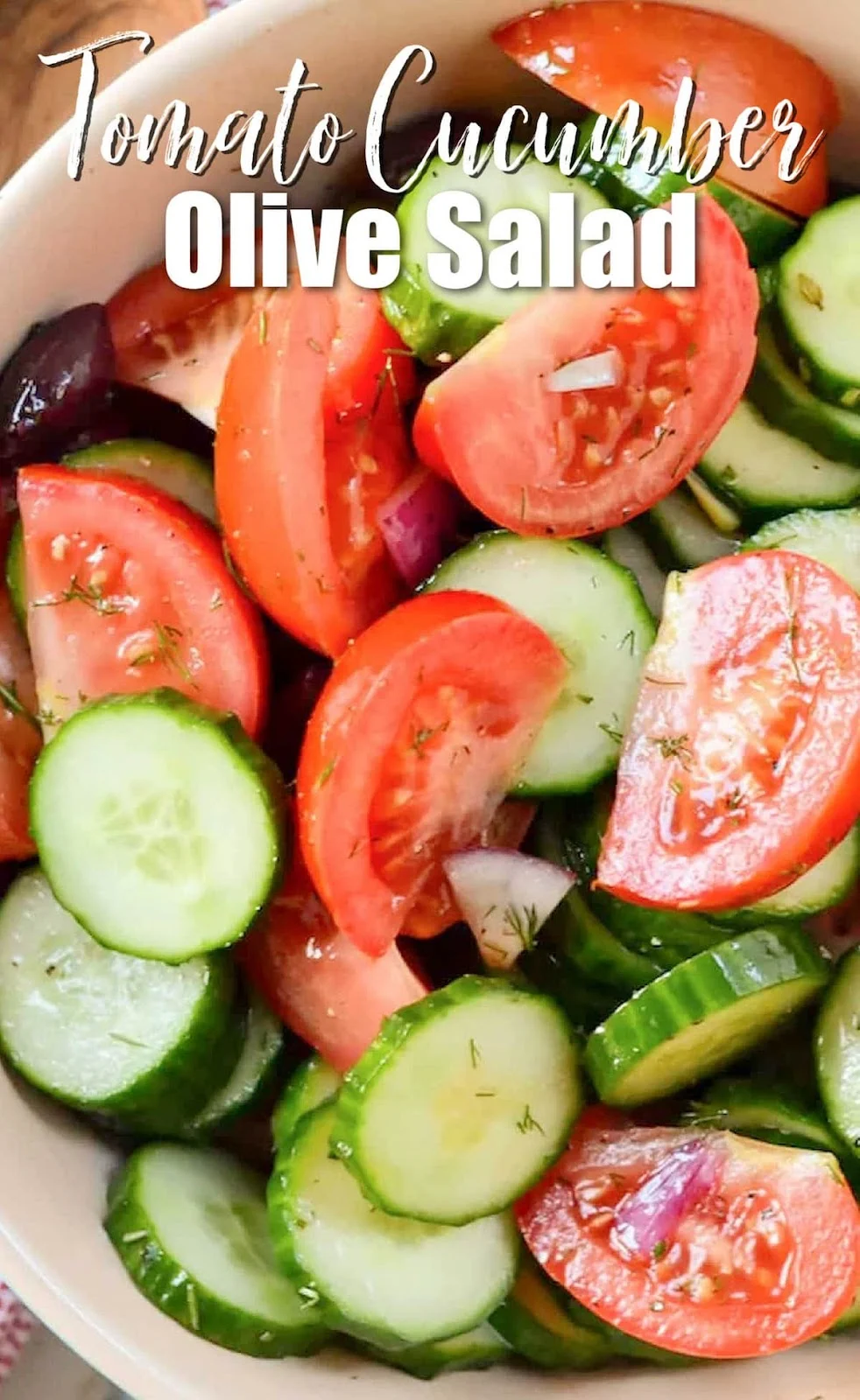 A down shot of Tomato Cucumber Olive Salad in a cream bowl with white text at the top of photo Tomato Cucumber Olive Salad.
