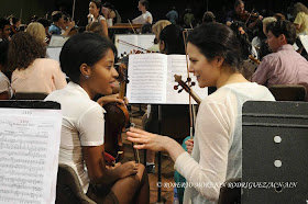 Una estudiante (I) de la Orquesta Juvenil del Conservatorio Amadeo Roldan conversa con una integrante (D) de la Orquesta Sinfónica de Minnesota,  durante el ensayo realizado en el Teatro Nacional de Cuba, en La Habana, el 15 de mayo de 2015.