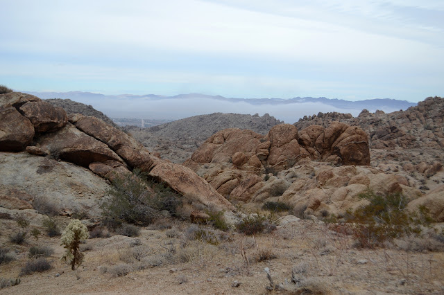 large rocks, small rocks, foggy city, and mountains