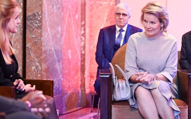 Queen Mathilde wore a gray cashmere asymmetric skirt by Natan, and cashmere sweater. Gold earring by Christine Bekaert