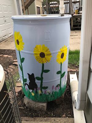 painted rain barrel with flowers and a cat