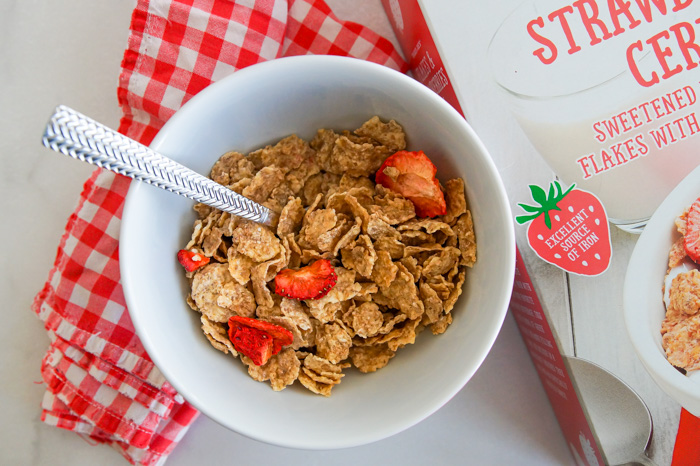 Trader Joe's Flakes & Strawberries Cereal in bowl with red gingham napkin