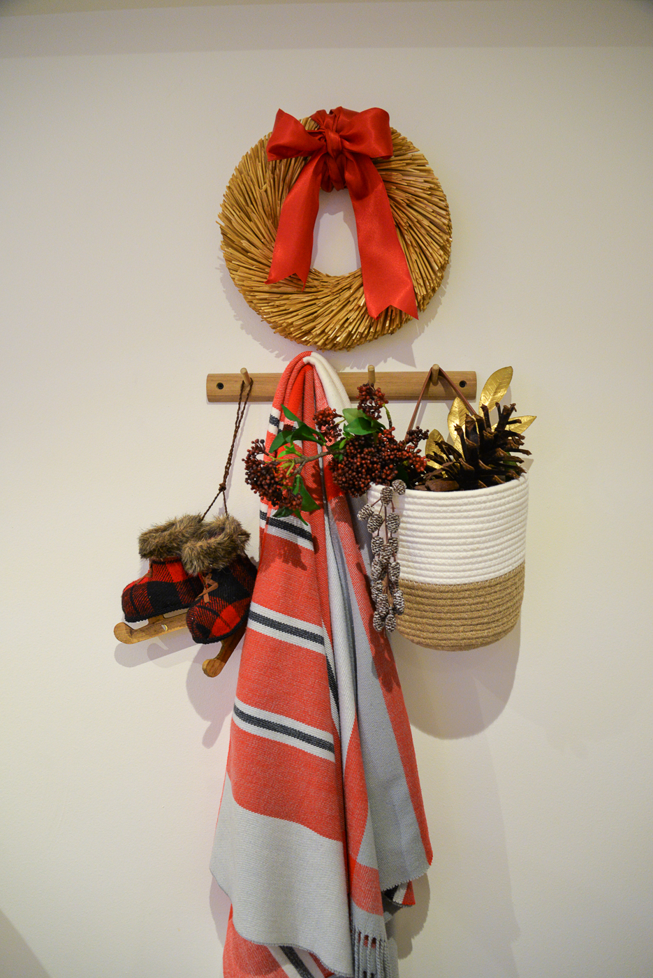 wooden peg rail with christmas ornaments and striped red throw