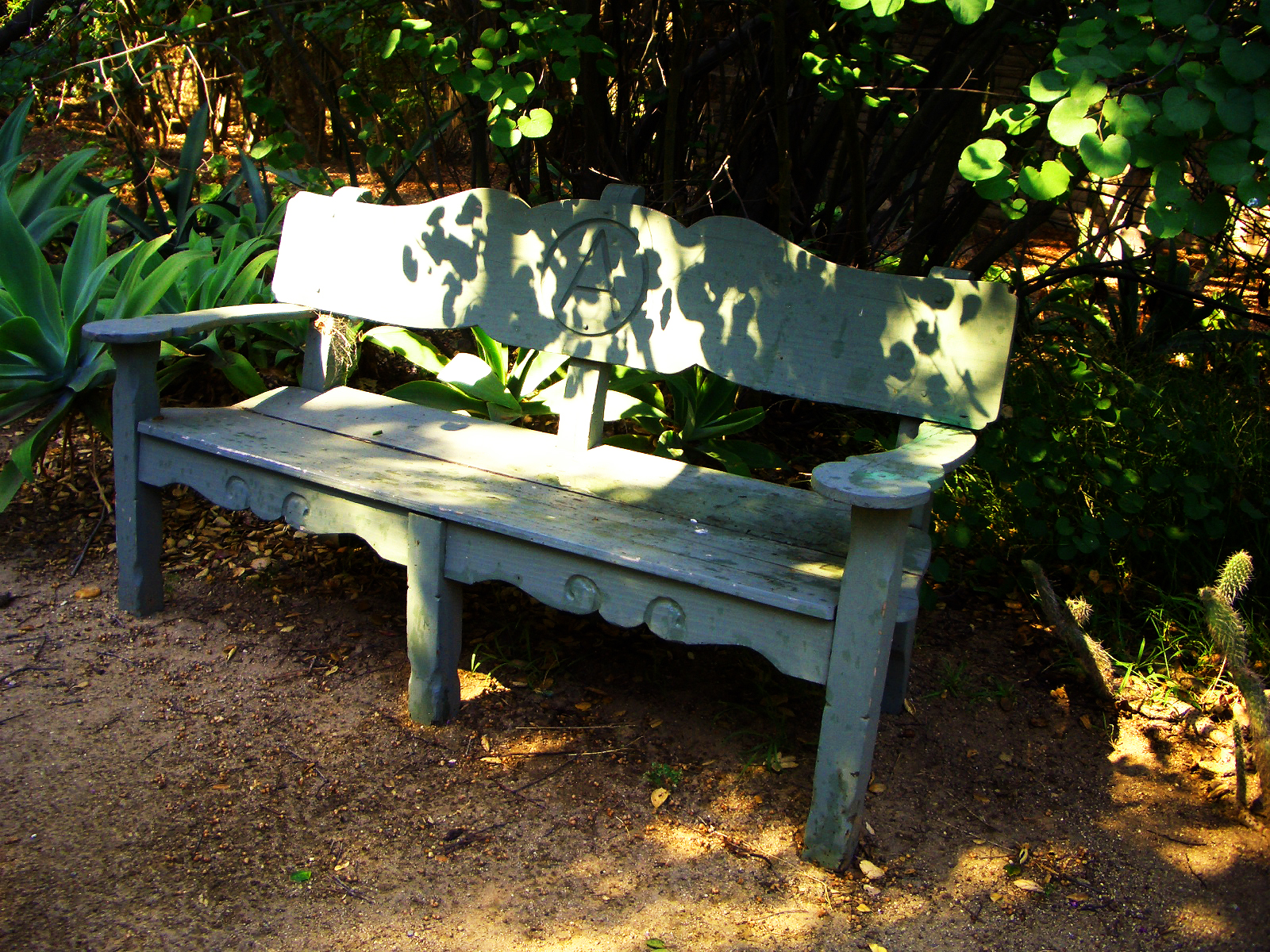  sculpture of three iron men supporting the minimalist wood bench