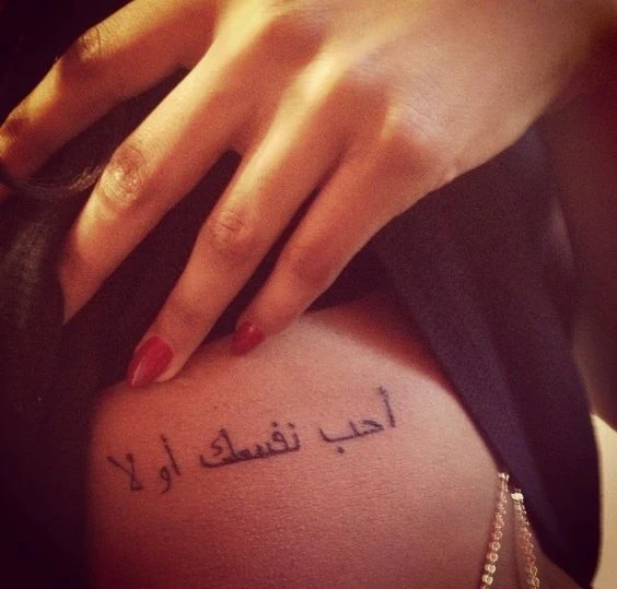 chica con tatuaje arabe debajo del pecho