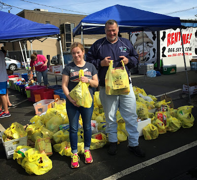 Erin Lynch, Franklin Food Pantry executive director, and Mike Catalano, Franklin Postmaster, lend a hand in the Stamp Out Hunger food drive for the Franklin Food Pantry