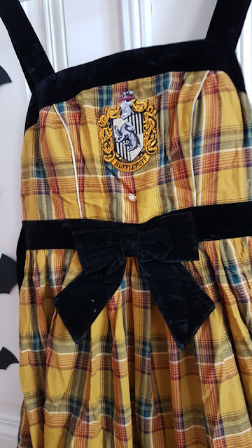 yellow plaid dress with black border and the word hufflepuff