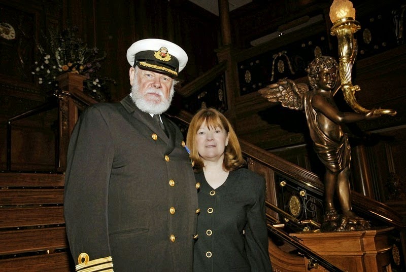 An actor dressed as the ship’s Captain poses with a visitor for a photograph. - The Titanic Museum in Branson