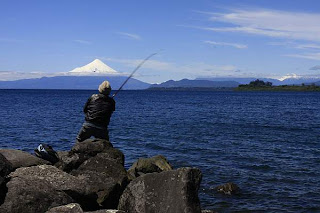 pescador con el volcán Osorno al fondo