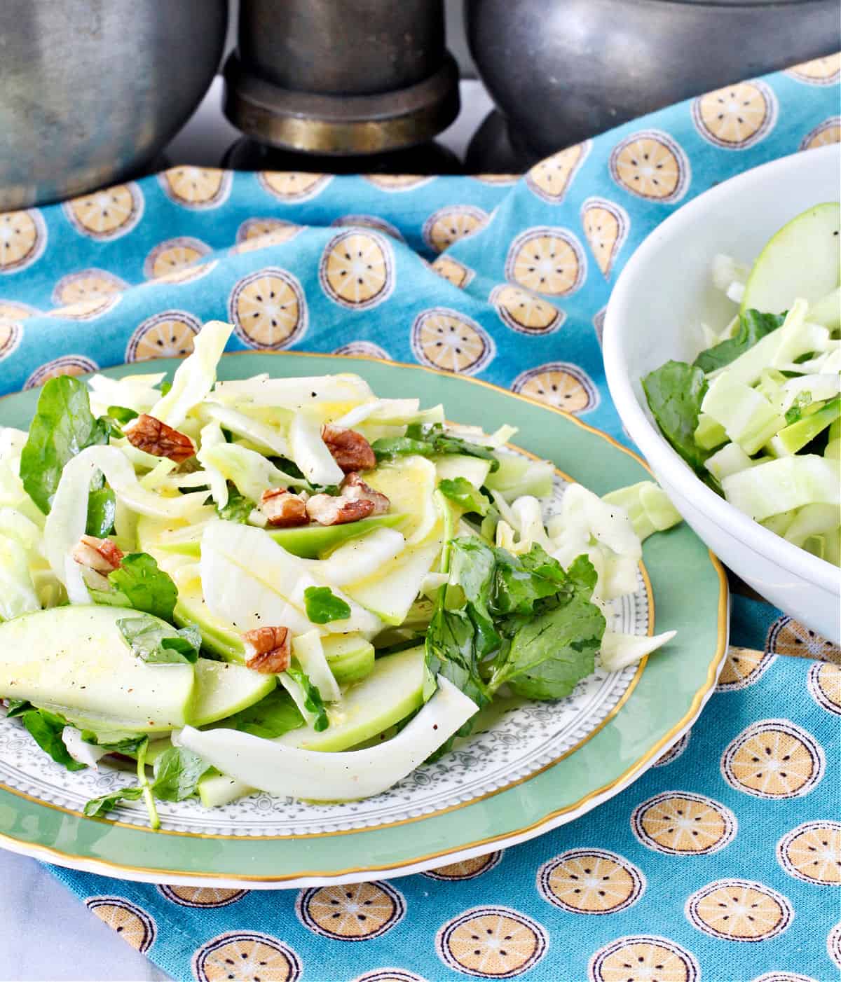 Green Cabbage and Apple Salad with Watercress and Pecans on a plate.