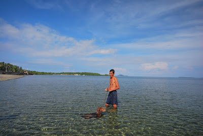 A dog and his master swimming during low tide at the beach of Inopacan, Leyte