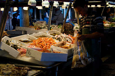 A vendor setting up a stall at the Fish Markets - Venice, Italy