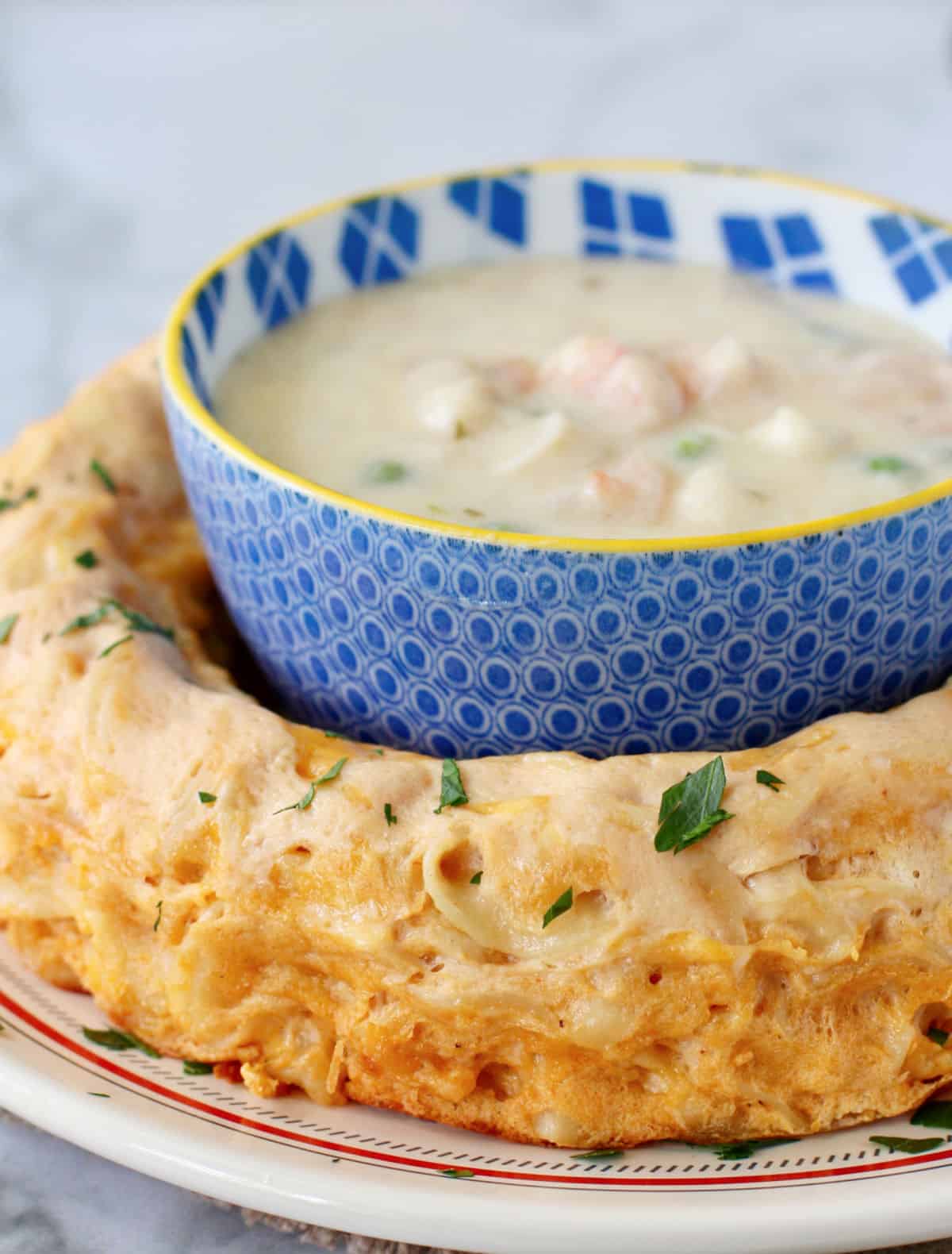 Cheesy Noodle Ring with a bowl of cream shrimp in the middle.