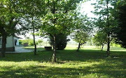 Giardino visto dall'angolo sudest: Vista della villa dalla strada in .