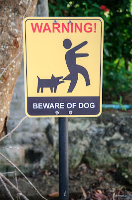 A dog that bites in one situation is not necessarily a threat in other situations, research shows. Photo shows funny dog biting sign.