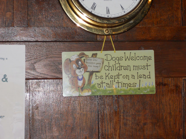 Sign behind bar. Dogs welcome children must be kept on leads.