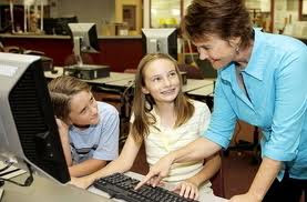 This picture of a teacher and two of her students using a computer shows an example of technology in the classroom.