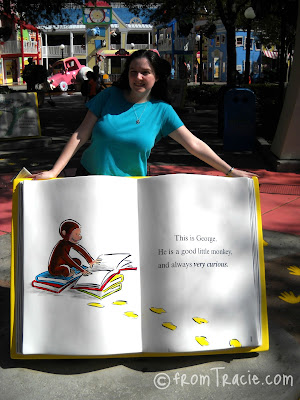 Tracie standing behind a giant Curious George Book