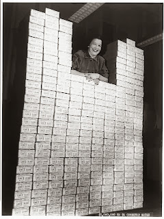 Woman posed with stack of packages of $1 silver certificates at the Bureau of Engraving and Printing, Washington, D.C. [between ca. 1950 and ca. 1969] Source - loc.gov/rr/business/money/paper.html