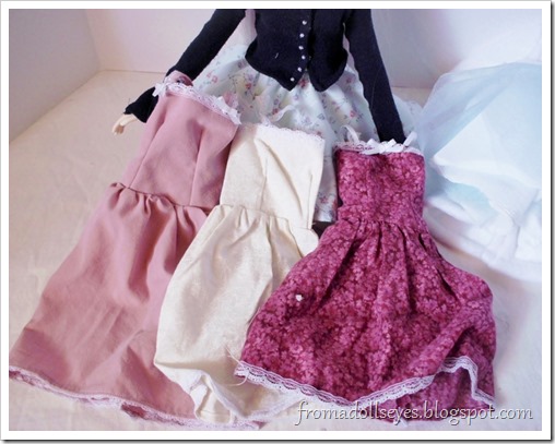 Sorting through pretty doll clothes.