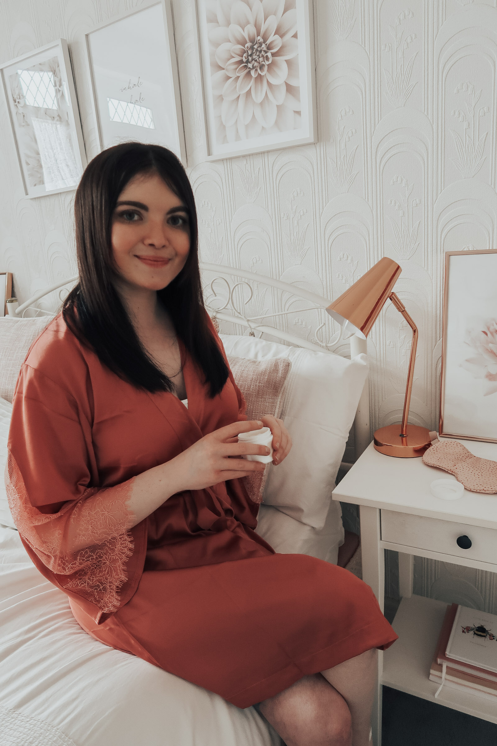 A woman holding a pot of night cream.