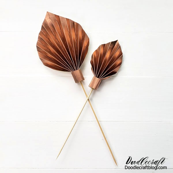 How to Make a Paper Palm Leaf Cake Topper! Learn how easy it is to make a paper palm leaf for the perfect cake topper, wedding centerpiece, buffet bar, tropical vibe party or home decor bouquet accent.  This fun frond is quick to make and just takes a couple supplies--get the kids to help too, they'll know just what to do!